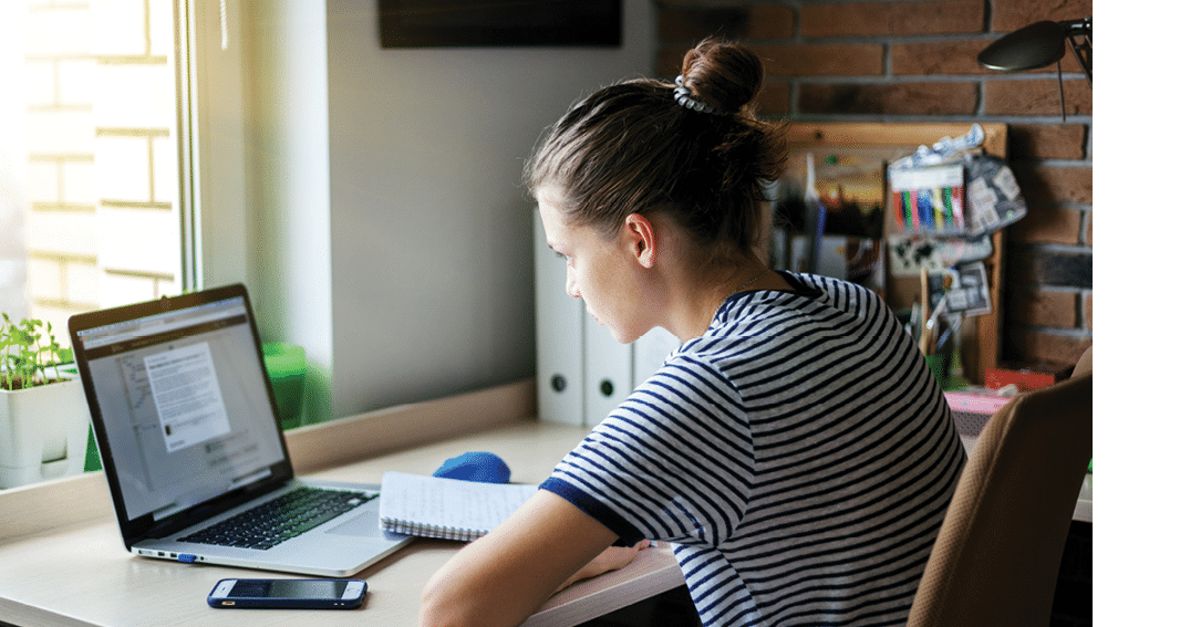 Girl student freelancer working with laptop at home by the window, education and remote work, programmer, online business