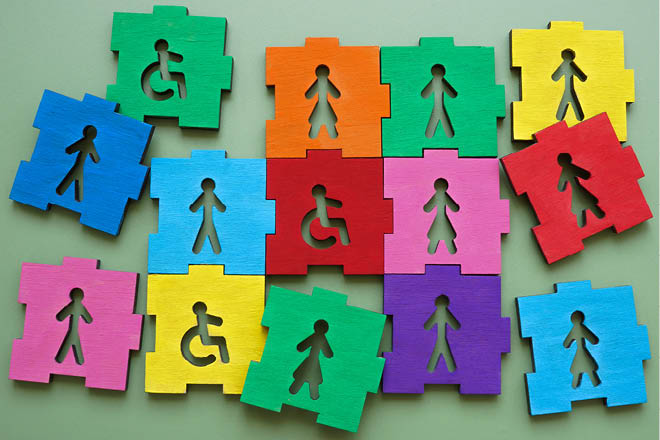 Puzzle pieces with male, female figures and disability sign representing inclusion and diversity.